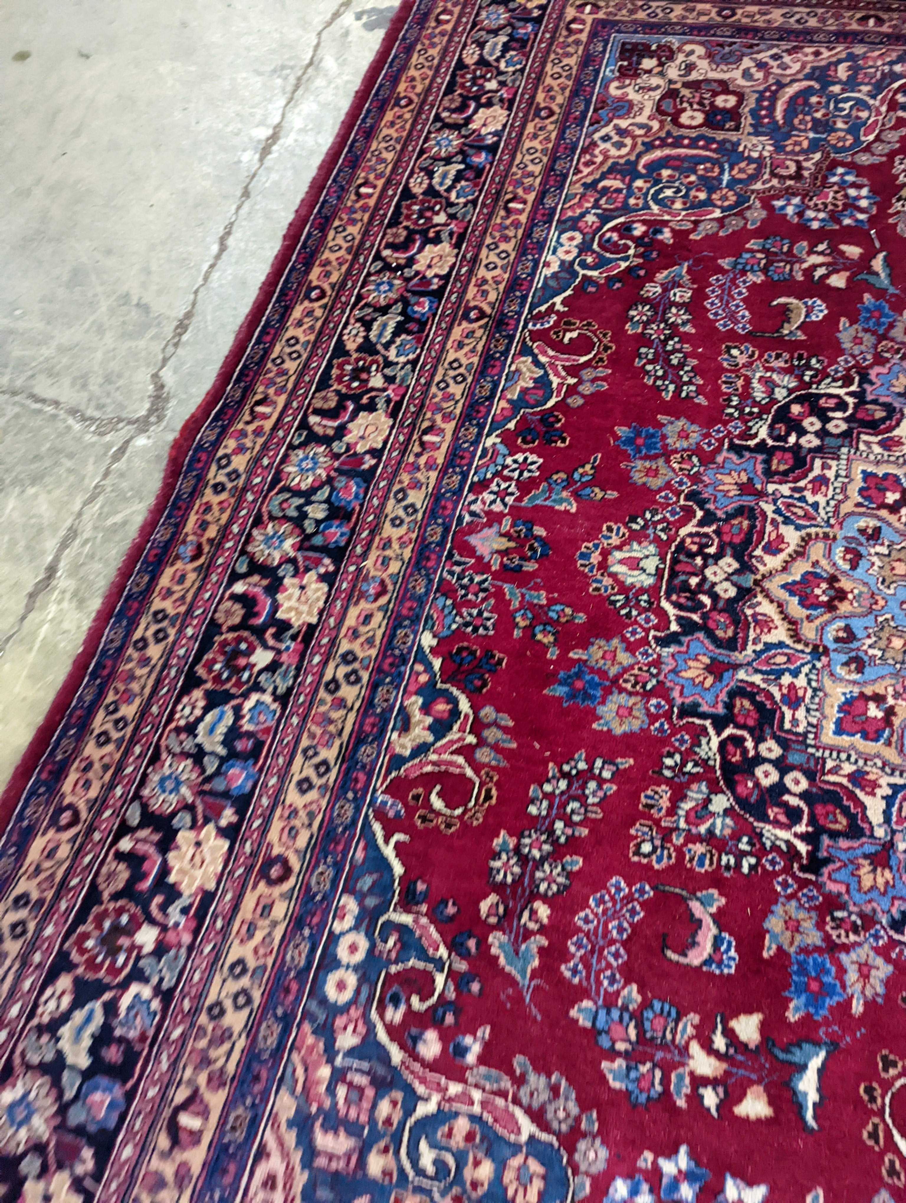 A Tabriz burgundy ground carpet, 350 x 250cm